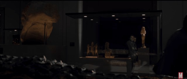 A mysterious museum exhibit featuring ancient artifacts and sculptures related to Moon Knight.