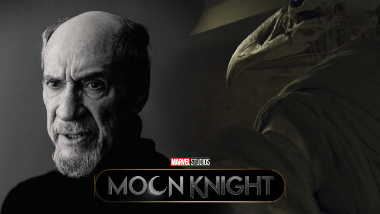A man with a serious expression, resembling Khonshu from Moon Knight, with a large bird-like statue.