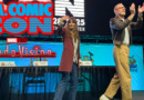 WandaVision panel recap banner, Elizabeth Olsen and Paul Bettany walking offstage with text "L.A. Comic Con" logo and "WandaVision" logo glowing red to the left of them