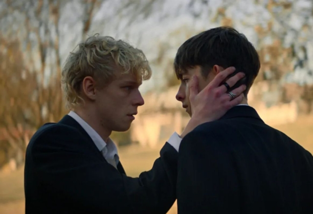 Two young men in formal suits face each other outdoors during daytime. Scene from the movie Leviticus
