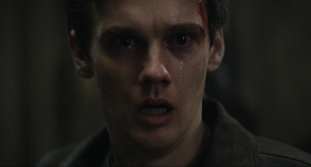 Close-up of a young man with tears and a shocked expression. Hunter Doohan in the movie Evil Dead Burn