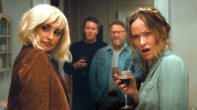 The Invite movie, Penelope Cruz and Olivia Wilde. Four people at a party, two women in the foreground, surprised expressions.